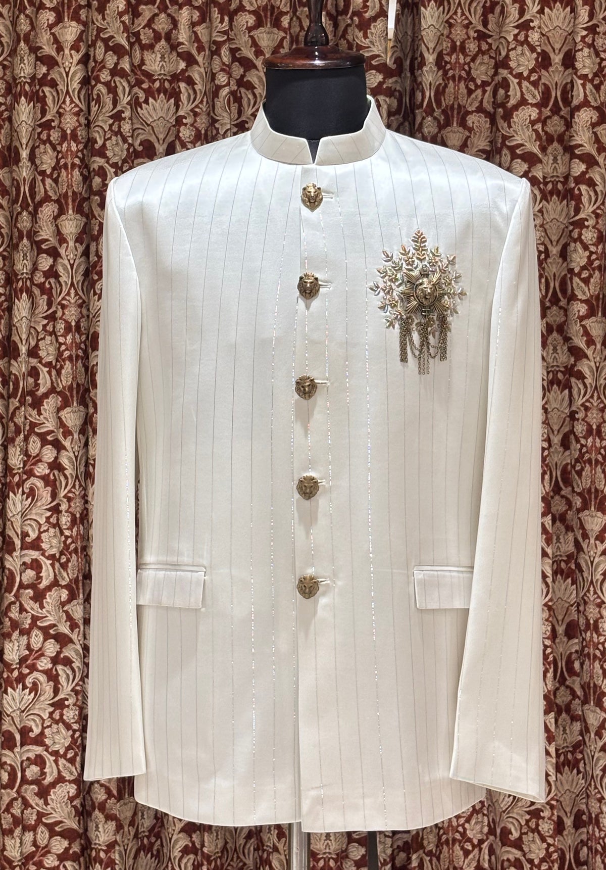 The Simhadhwaja Jodhpuri with lion emblem detailing, vertical pinstripes and intricate floral embroidery
